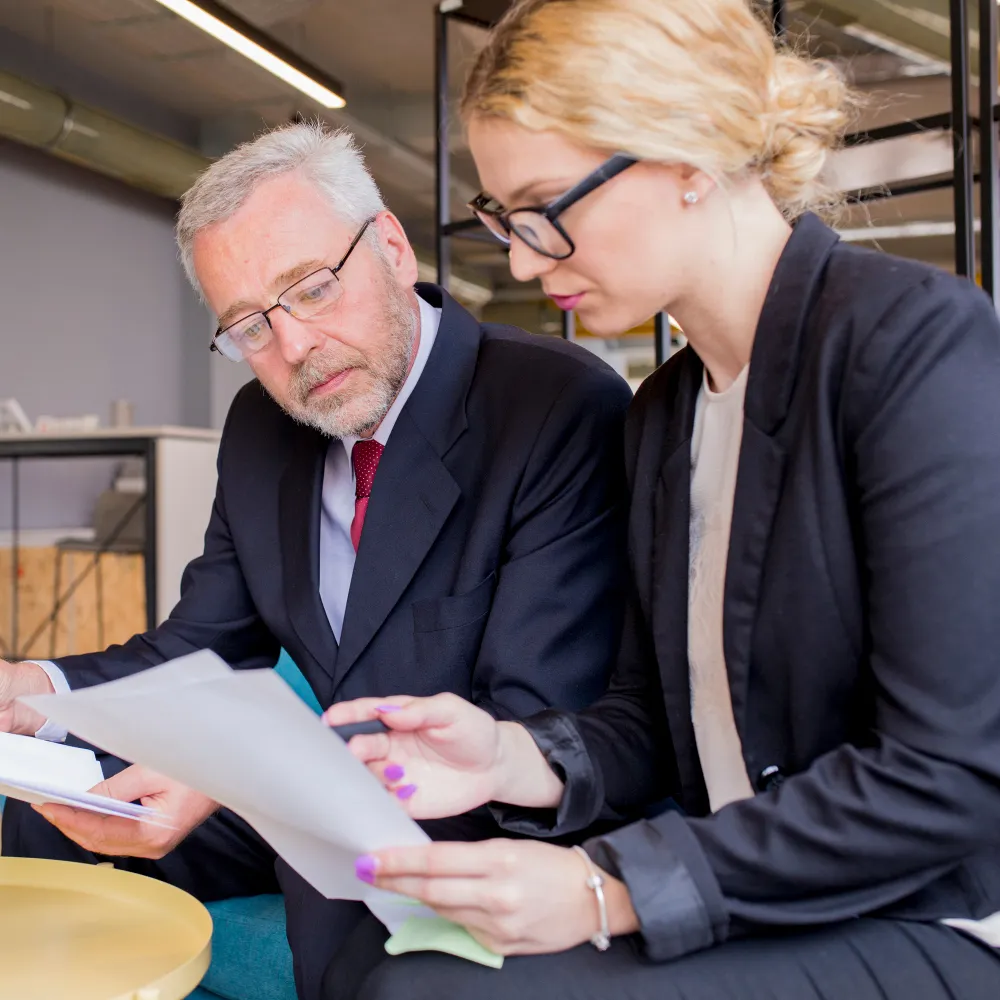Two professionals reviewing documents in an office