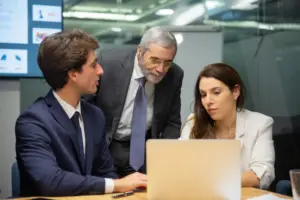 Business professionals discussing data on a laptop during a meeting