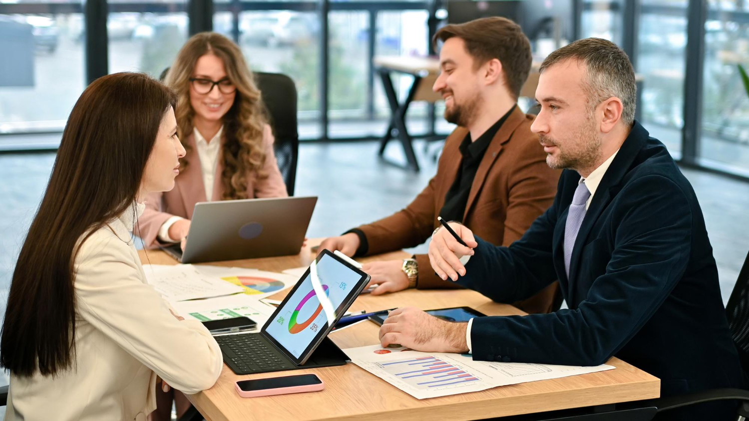 Business executives discussing data on a laptop during a meeting