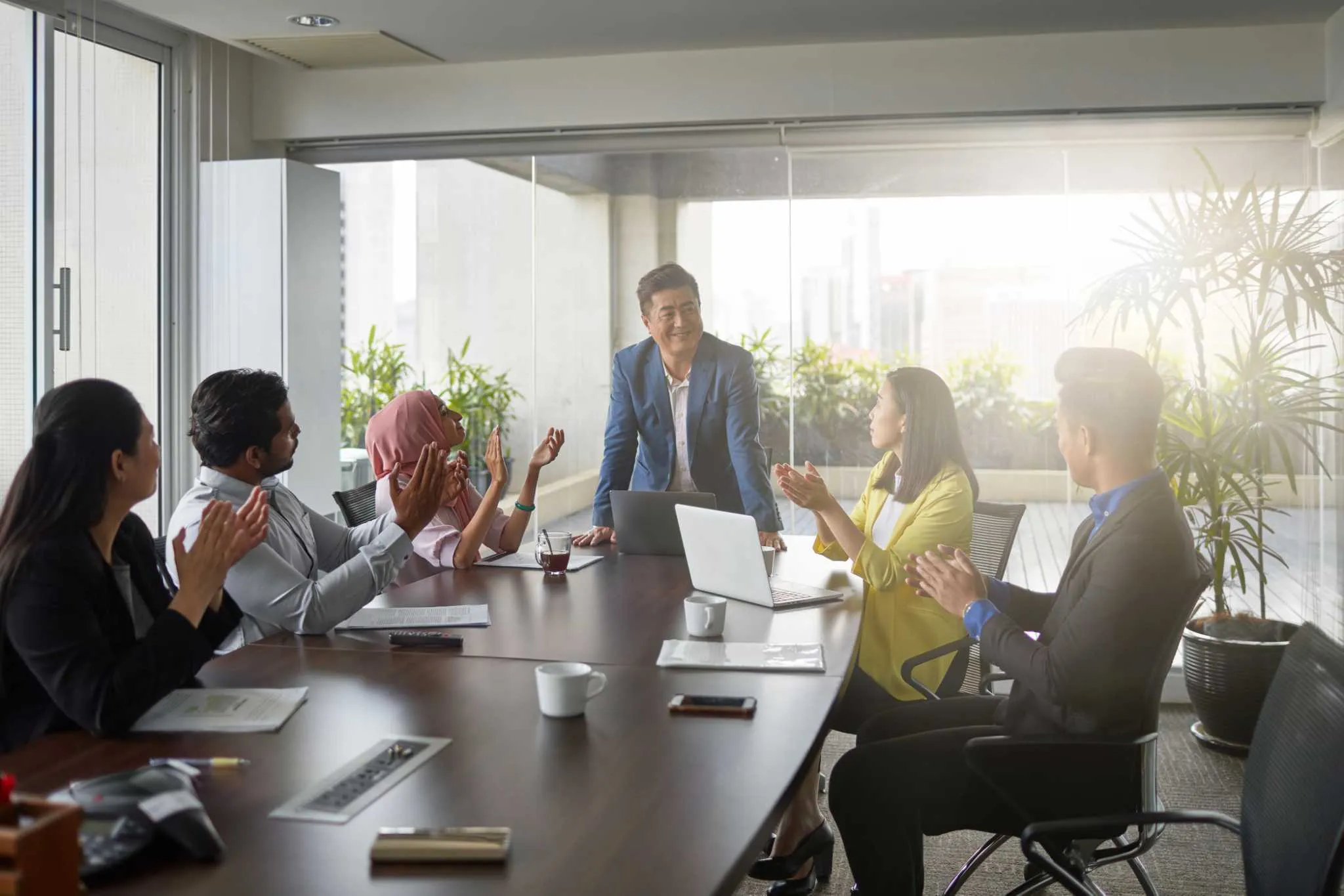 Team applauding a leader during a meeting presentation
